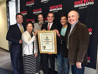 Los Angeles Mayor Eric Garcetti (center) presents KNX with a proclamation to celebrate 50 years of service to the city. Frank Mottek, Julie Chi, Ken Charles, Charles Feldman and Dick Helton accepted on behalf of all
